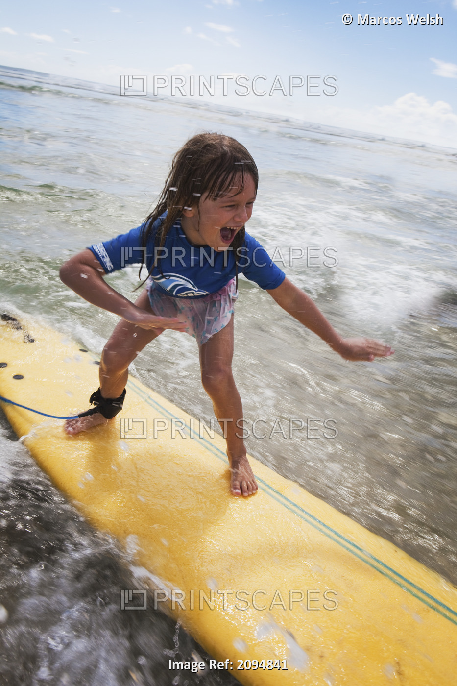A young girl on a yellow surfboard;Gold coast queensland australia