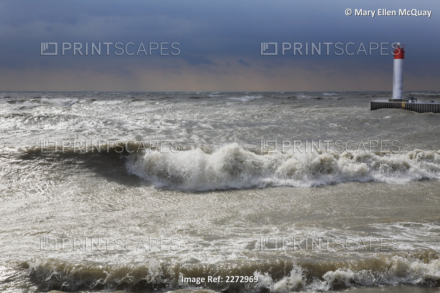Storm waves crashing on a beach near a lighthouse on lake ontario; whitby ...