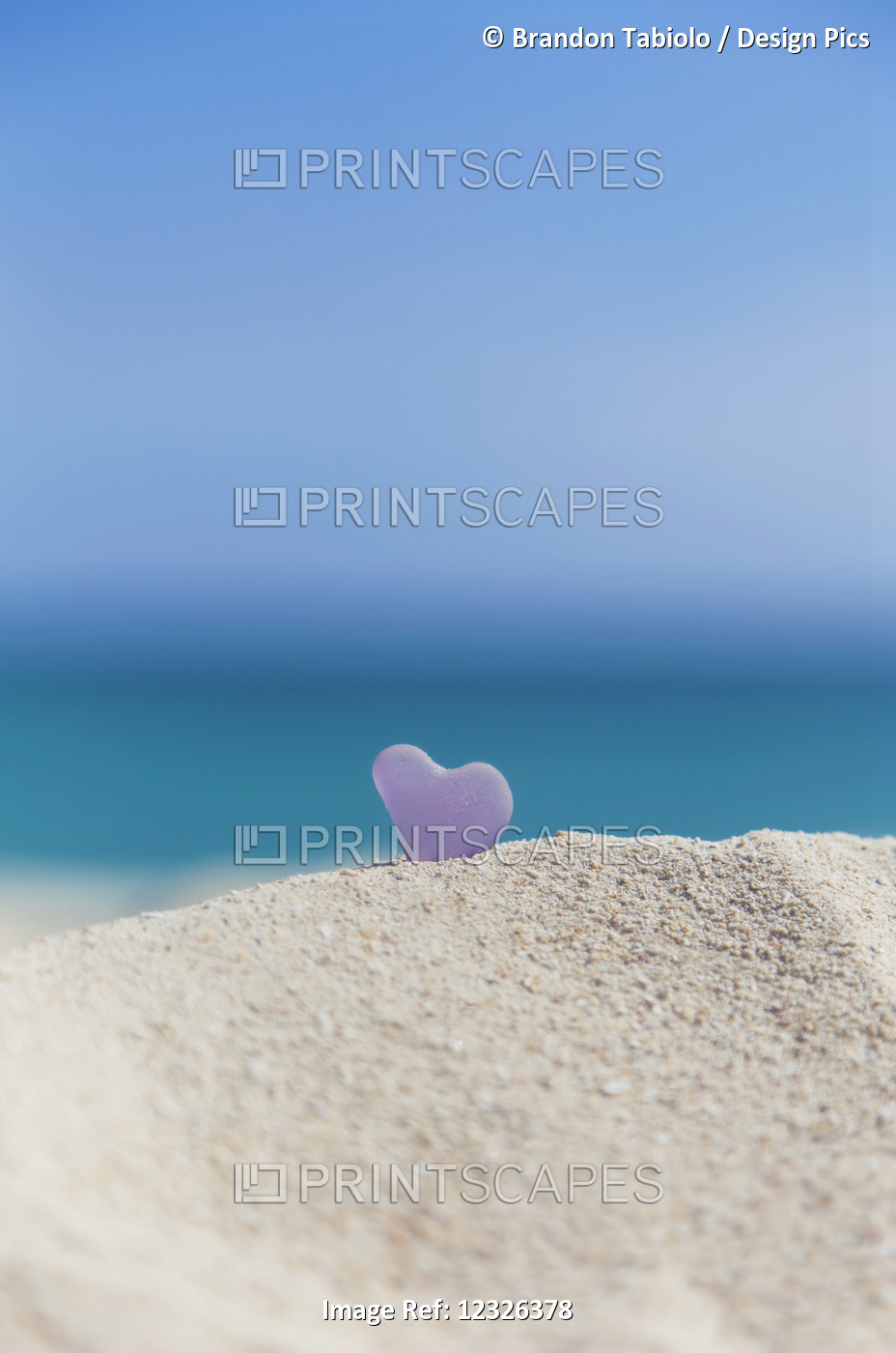 A Lavender Heart Shaped Sea Glass In The Sand At The Beach; Honolulu, Oahu, ...