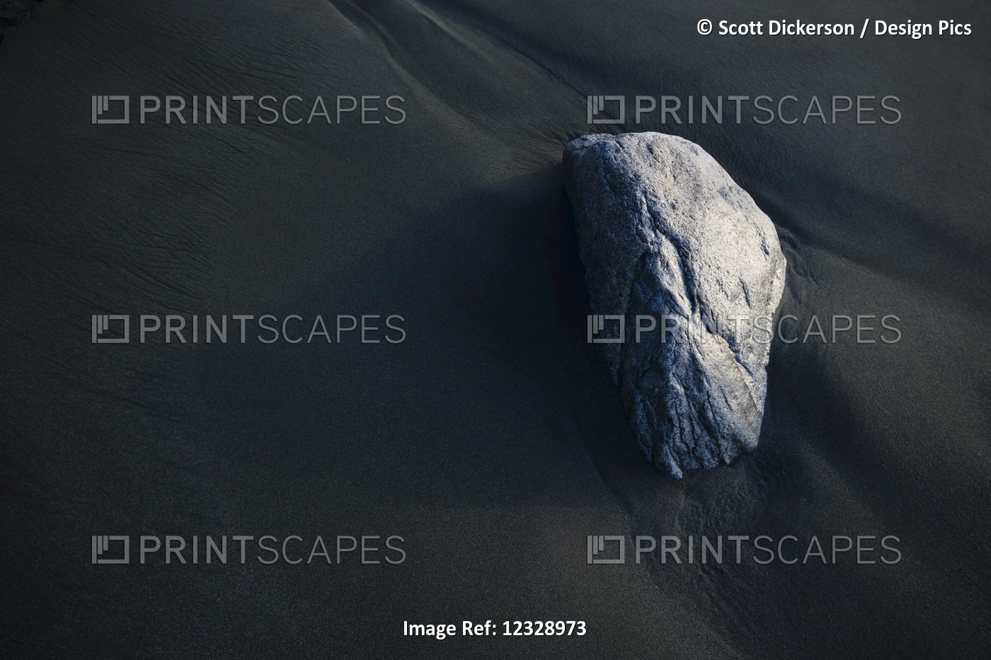 A Rock Sits On The Dark, Wet Sand; Alaska, United States Of America