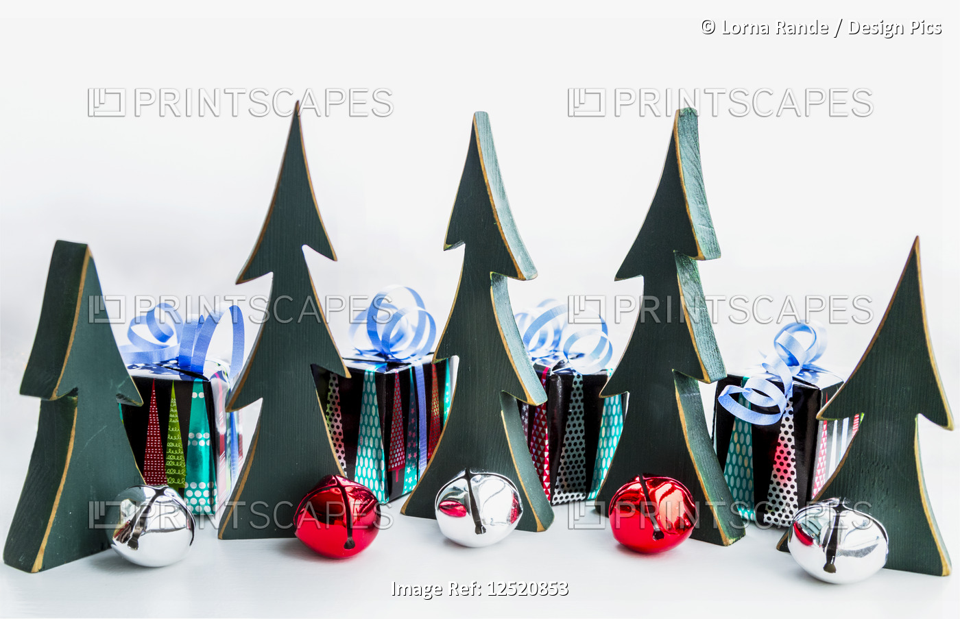 Miniature wooden trees, bells and wrapped gifts as decorations for Christmas