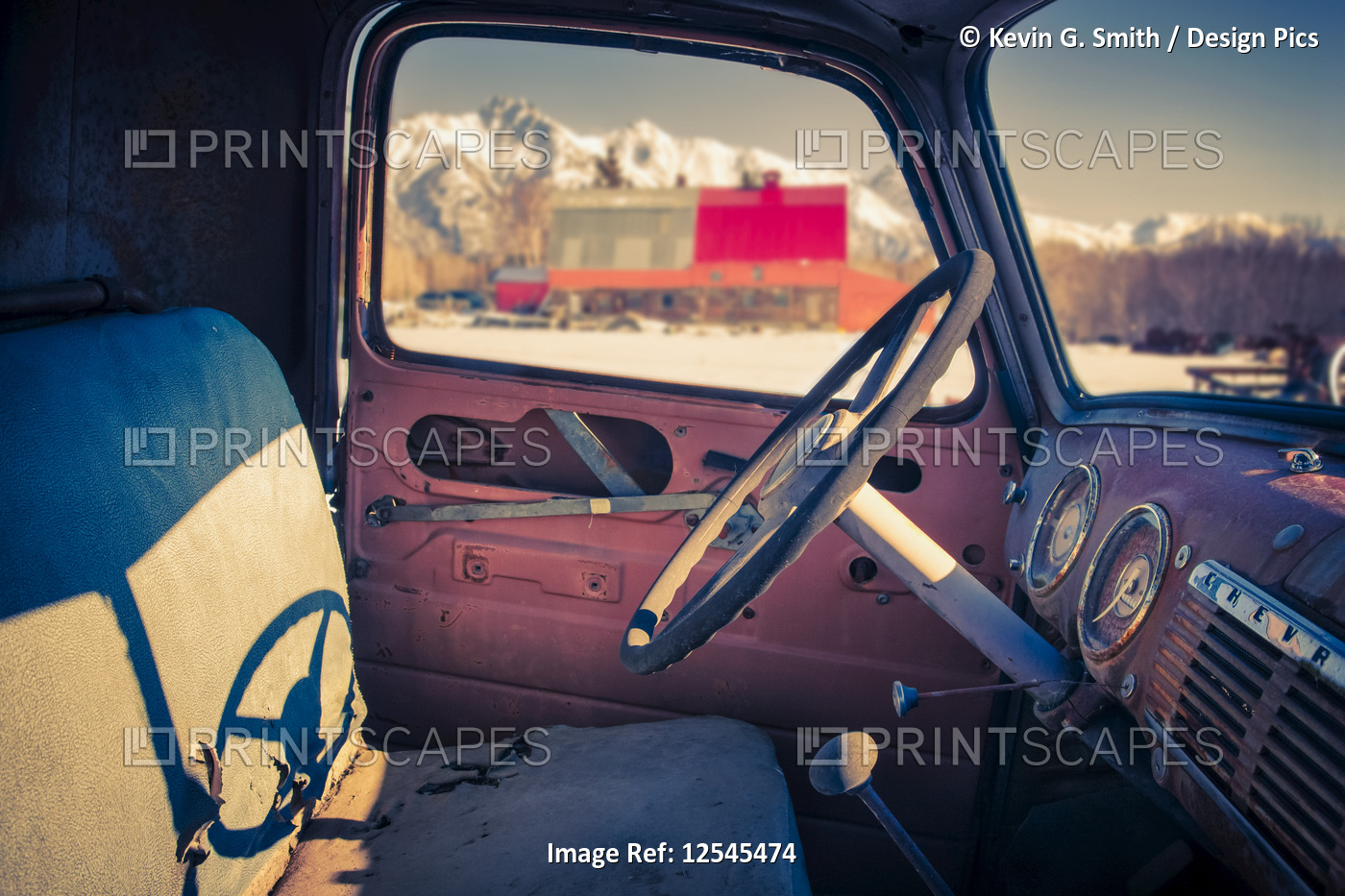 Interior view of a old, worn truck with Pioneer Peak visible out of the ...