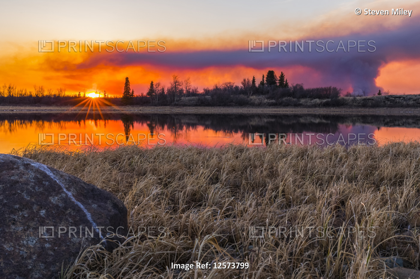 A plume of smoke rising from the 2019 Oregon Lakes fire reflects in a lake at ...