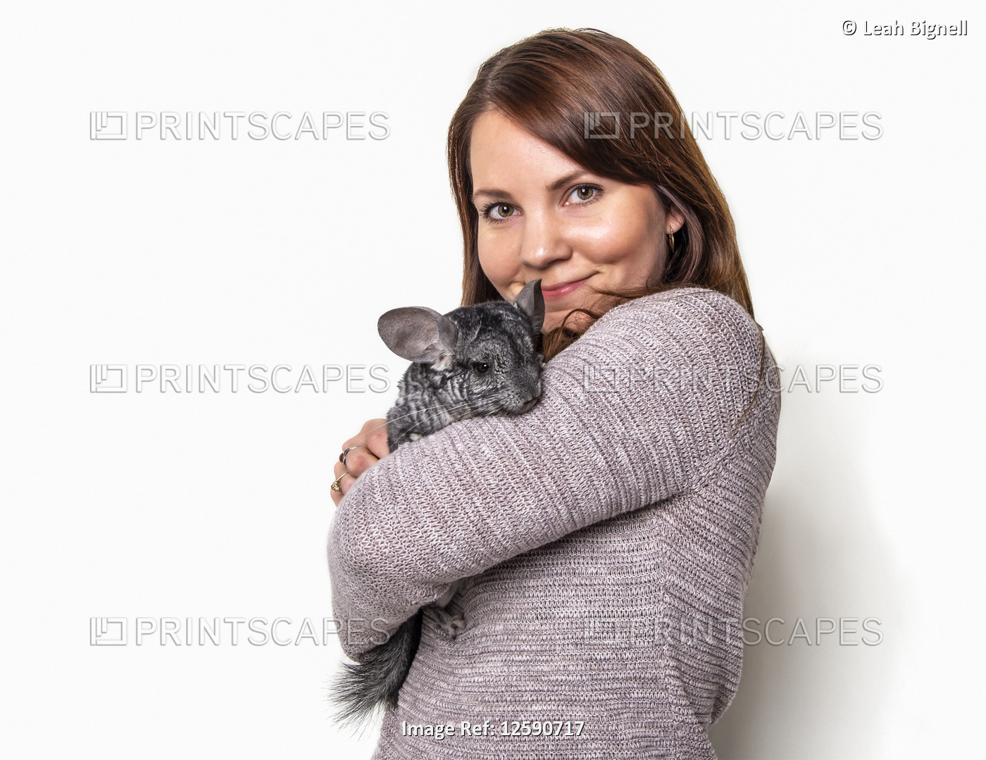 A woman holding her pet chinchilla against a white background; Studio