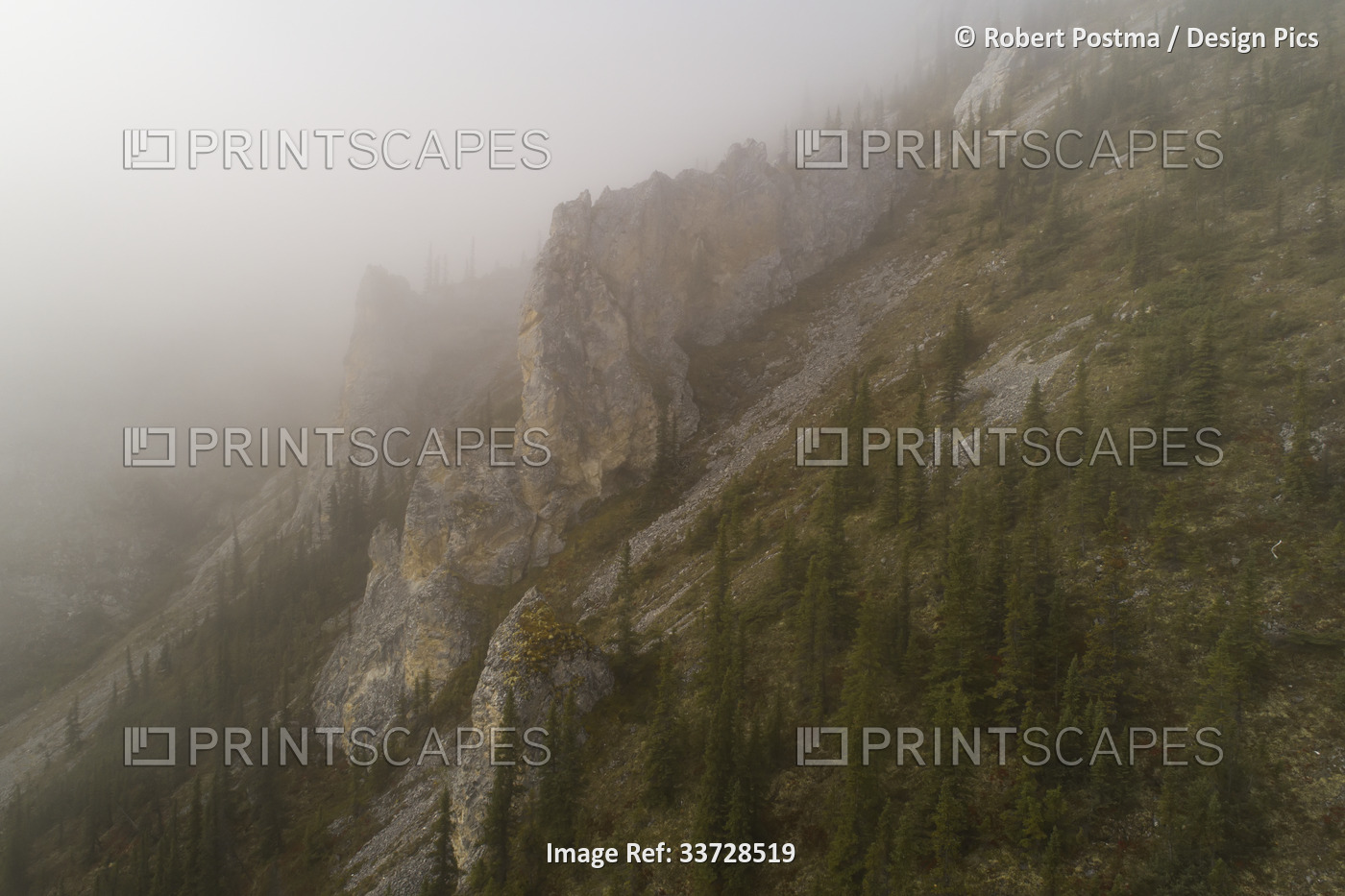 Aerial image of a misty mountain in the Ogilvie Mountains with castellations ...
