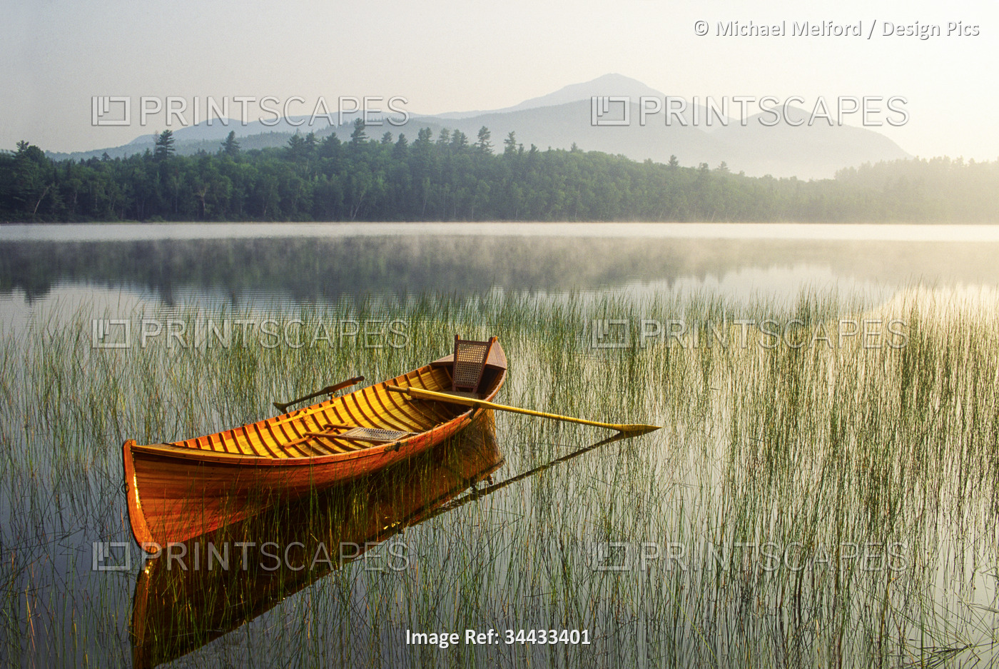 Adirondack Guide Boat in a calm lake with Whiteface Mountain in the background, ...