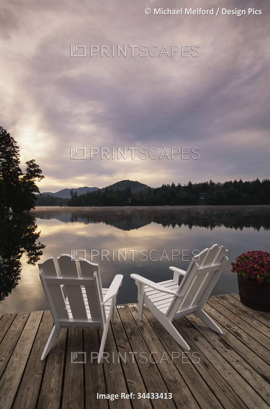 Pair of Adirondack chairs on a dock at a lake in the Adirondack Mountains, New ...