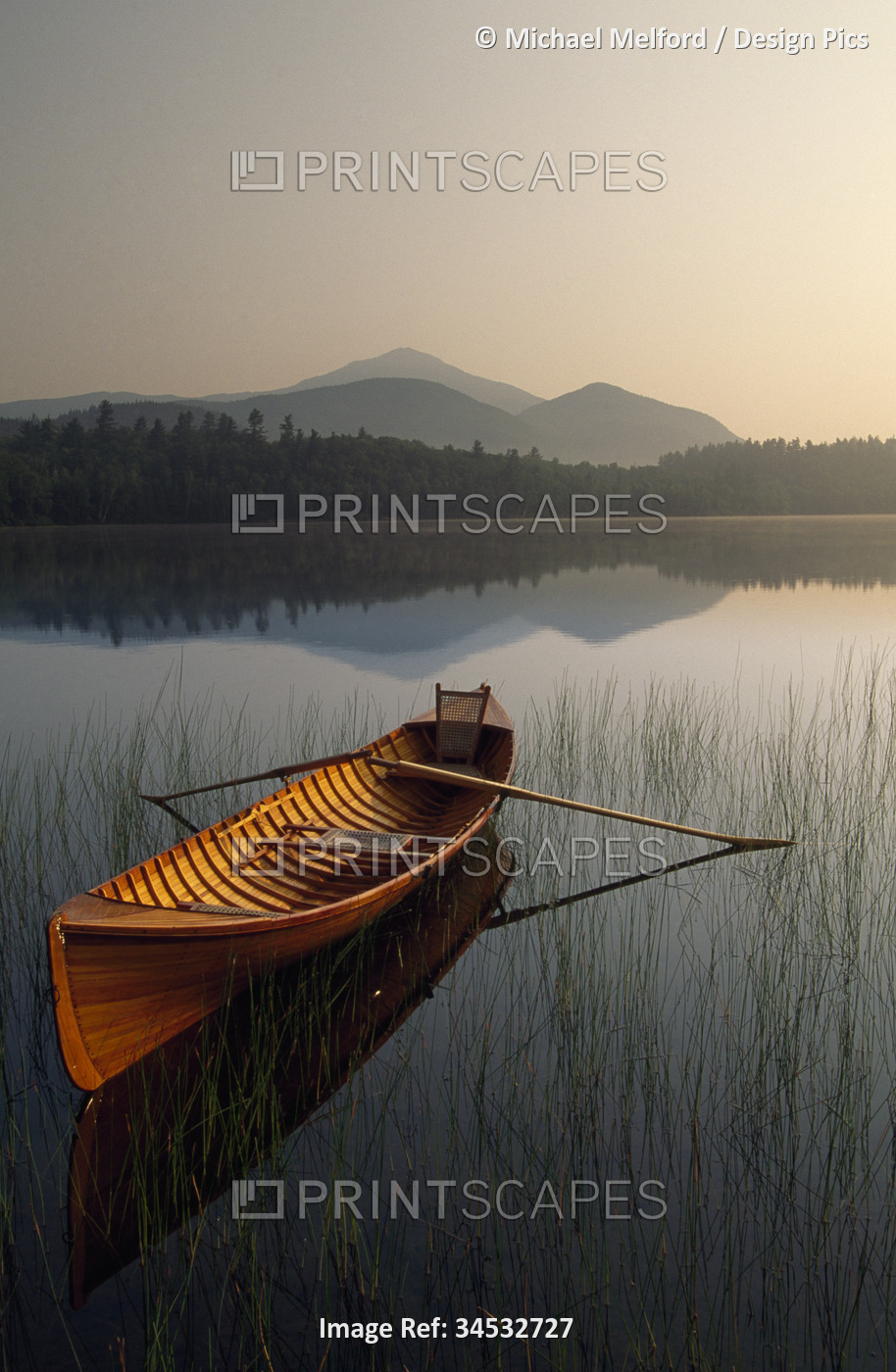 Boat with oars floating on a tranquil lake a twilight in Adirondack Park, New ...