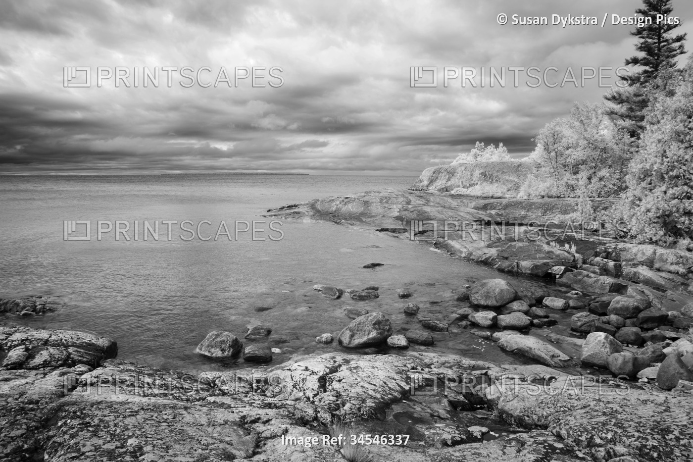 Dramatic clouds over Lake Superior and a rocky shoreline in infrared