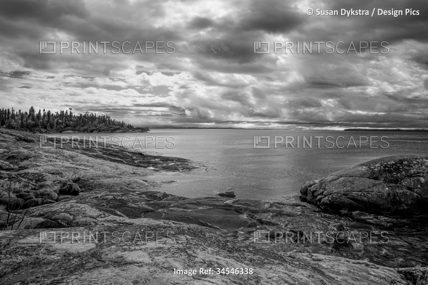 Dramatic clouds over Lake Superior and a rocky shoreline in infrared