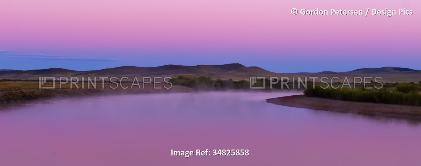 Onan River at dawn in Northeastern Mongolia, with pink light in the sky and ...